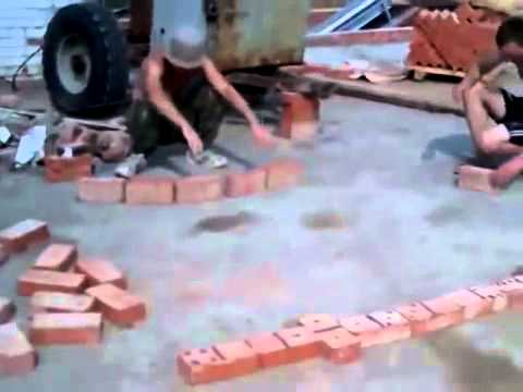Суровые строители играют в домино кирпичями, Severe builders play the